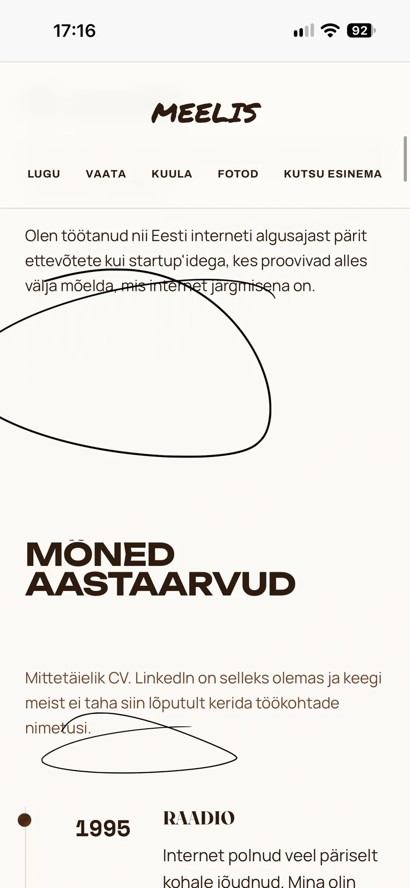 Meelis Vill ülikonnas istumas, klaas laual